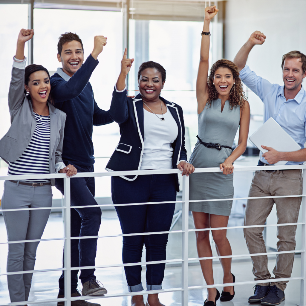 Entreprise avec une équipe de collaborateurs qui se soutiennent et vont vers un but commun les bras vers le ciel et avec le sourire